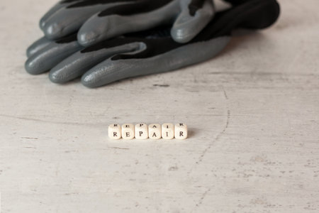 Gray with black work gloves on the background of the inscription repair in the foreground. Concept safety in the workplace. DIY.の写真素材