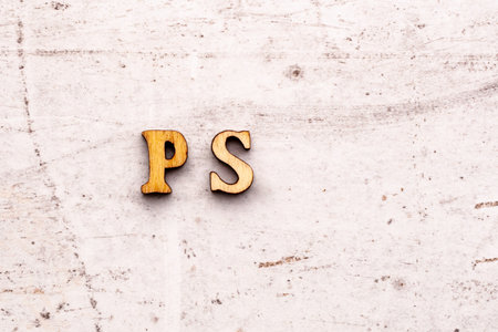Inscription PS post scriptum abbreviation in wooden letters on a light backgroundの写真素材