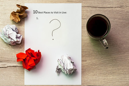 The inscription on a white sheet of A4 10 best plases to visit in live. Cup of coffee and question...