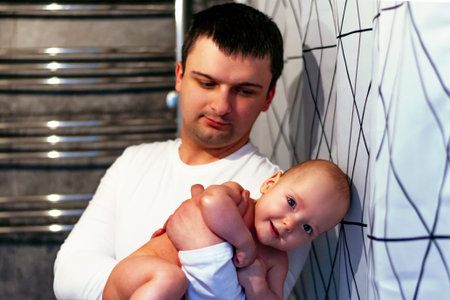 Father washes out the baby in the bathroom. Paternity
