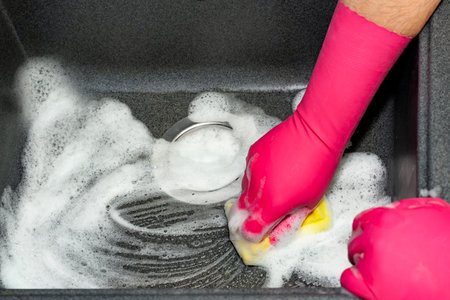 The process of washing the dark sink, hands close-up. A man in pink gloves washes a sink. Cleaning, clean upの写真素材
