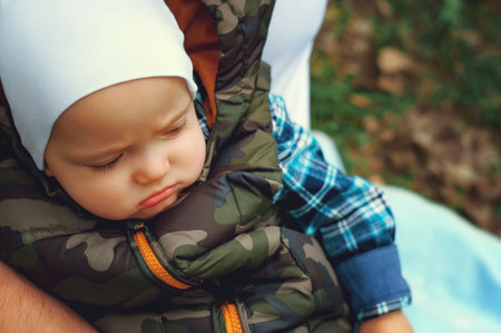 A child in the arms of his dad on the street, spring. Father walks with the child.の写真素材