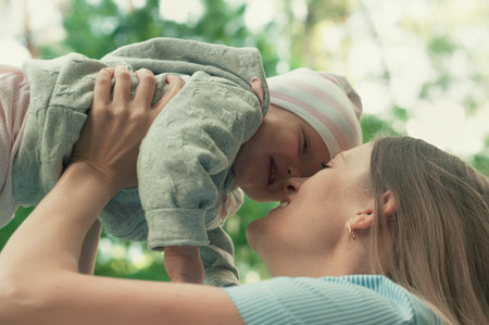 Mom walks with the baby in the park. The baby in her arms. Springの写真素材