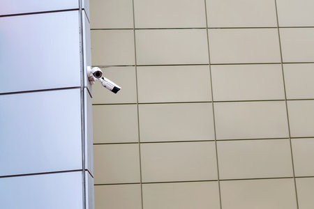 Surveillance camera on the corner of the house. Security and control.の写真素材