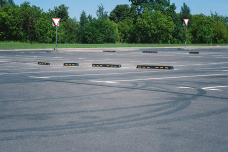 Modern rubber barrier for cars in the summer parking. Tire tracks on asphalt