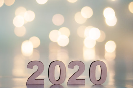 The inscription 2020, New Year and Christmas, from behind blurred dots of light on a blue background. Christmas and holidayの写真素材