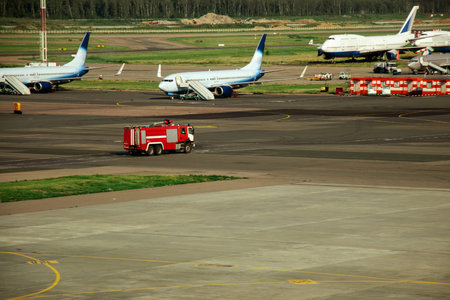 Fire truck on the runway near the aircraft. Airport Rescue Service. Firefighters and fire department...