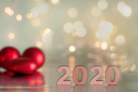 The inscription 2020, New Year and Christmas, from behind blurred dots of light on a blue background and red balls on the Christmas tree. Christmas and holidayの写真素材