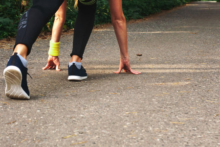 Feet step runner on the road, closeup shoes. Start running on the sidelines. Run outdoor exercise...