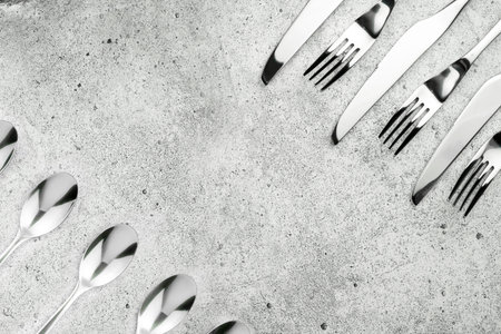 Cutlery. Forks and knives on a light concrete background. Place for an inscription. Flat lay, top...