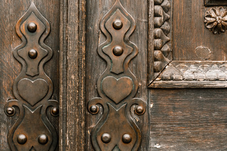 Old forged wooden door. Forged metal elements in the interior. Design and interior.の写真素材