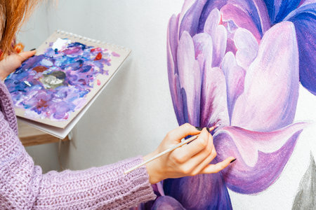 Artist. Designer. Young girl artist paints on a wall indoors. Interior Design. The creative processの写真素材