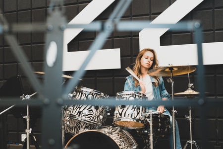 Creativity and music. Young beautiful girl plays the drums. Recording Studio. Musical equipment.の写真素材