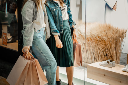 Trade, buyers. Two beautiful girls make purchases in a shopping center, go shopping. The joy of consumptionの写真素材