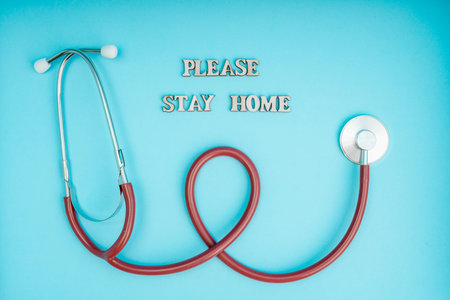 Coronavirus, covid-19. The inscription stay home on a blue background. Self-isolation and quarantine, personal protective equipment, phonendoscope and stethoscope.の写真素材