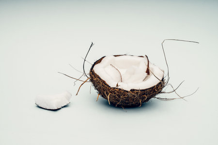 Parts of coconut on a colored background. Close up. Fresh ripe coconut broken into piecesの写真素材