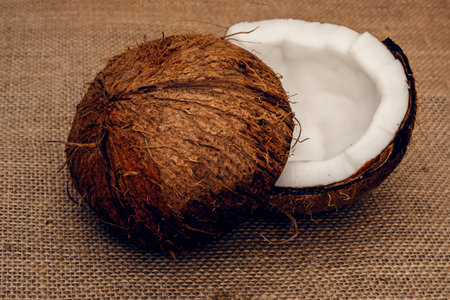 Parts of coconut on a colored background. Close up. Fresh ripe coconut broken into pieces