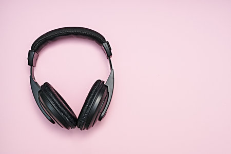 Large, black headphones lie on a colored background. Device for individual listening to musicの写真素材