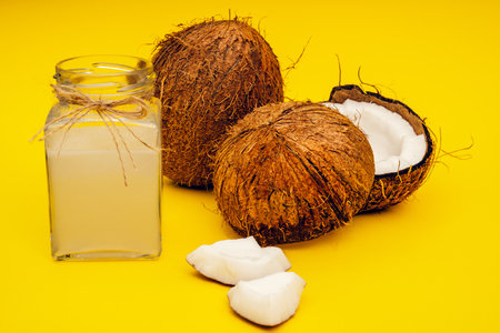 Parts of coconut on a colored background. Close up. Fresh ripe coconut broken into pieces.の写真素材