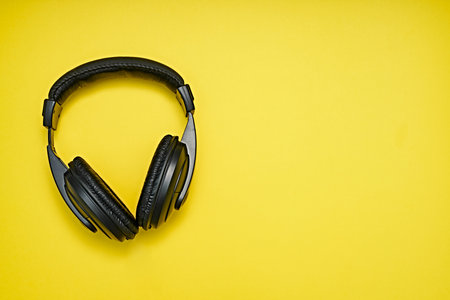 Large, black headphones lie on a colored background. Device for individual listening to musicの写真素材