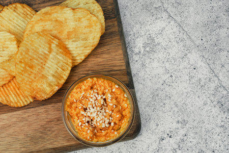 Potato chips on a wooden stand with sauces. Ready meal from the menu. Unhealthy food and beer snack