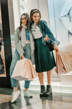Trade, buyers. Two beautiful girls make purchases in a shopping center, go shopping. The joy of consumption.の写真素材