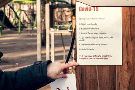 Note covid-19, what you need to know. Hanging on on an empty playground in a park. Self-isolation and quarantine in a pandemic.の写真素材