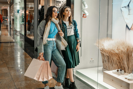 Trade, buyers. Two beautiful girls make purchases in a shopping center, go shopping. The joy of consumption.の写真素材