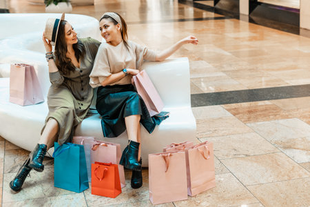 Girls are resting on the couch in the mall. Shopping, entertainment and leisure. Break in purchases.の写真素材