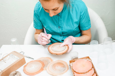 Creativity and craft. A young girl creates coasters from resin. Gift wrapping. Decorative packaging. Idea for business. Remote work, work at home. Art coasters.の写真素材