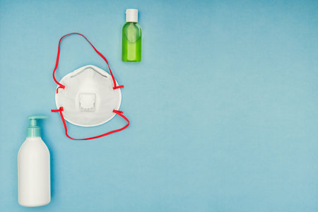 Coronavirus, covid-19. Antiseptic gel, liquid we, protective mask on a blue background. Self-isolation and quarantine, personal protective equipment.の写真素材