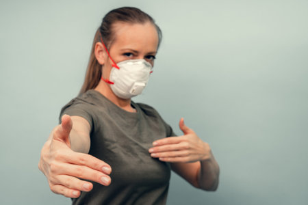 A girl is putting on a protective mask. Respiratory protection from coronavirus. Keep the distance. Personal protective equipment for a pandemic of a viral infection. Covid-19.の写真素材