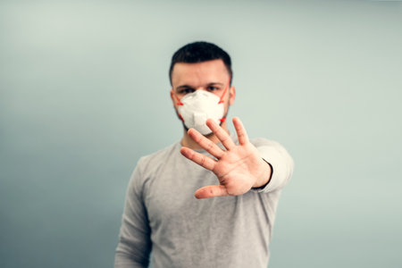 A man is putting on a protective mask. Respiratory protection from coronavirus. Personal protective equipment for a pandemic of a viral infection. Covid-19.の写真素材