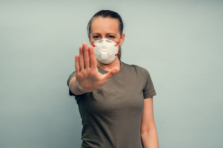 A girl is putting on a protective mask. Respiratory protection from coronavirus. Keep the distance. Personal protective equipment for a pandemic of a viral infection. Covid-19.の写真素材