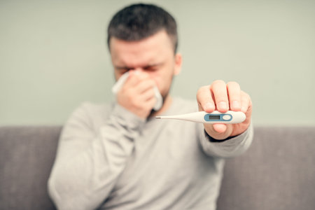 Disease. Cheer at home. A young man is sick, is treated at home. Blows her nose into a napkin, runny...