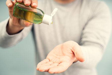 Applying an antiseptic to male hands. Personal protective equipment for the coronavirus pandemic.の写真素材