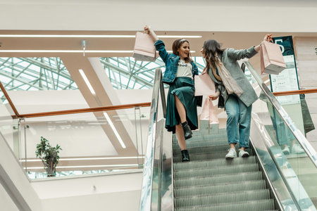 Trade, buyers. Two beautiful girls make purchases in a shopping center, go shopping. The joy of consumption.の写真素材