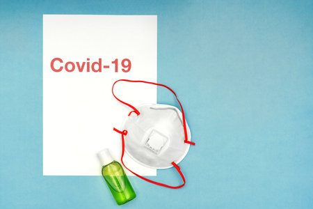 Coronavirus, covid-19. The inscription covid-19 on a blue background. Self-isolation and quarantine, personal protective equipment, ampoule and syringe.の写真素材