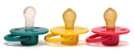 Three baby\'s dummy red, yellow and green isolated on white .の写真素材
