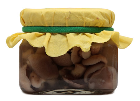 Glass jar with pickled mushrooms isolated on a white の写真素材