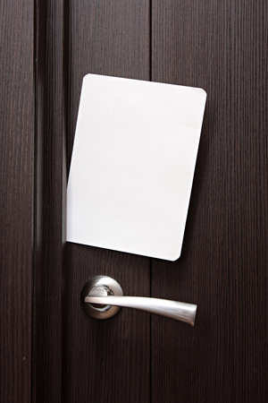 white envelope with message slipped under wooden door. Blank paper to write a nested in the gap under the wooden door.の写真素材