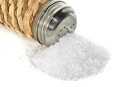 Scattered small group of salt and saltcellar on a white backgroundの写真素材