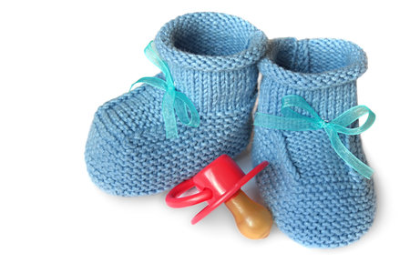 pair of blue knit children's bootees and baby's dummyの写真素材