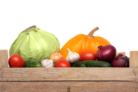 Assortment of vegetables in a wooden box. Pumpkin, tomato, cucumber, onion, garlic, carrot. Shooting in Studio, isolated on white background.の写真素材