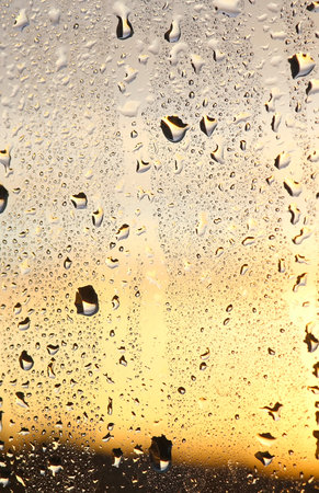 Rain drops on glass. The sunset in the backgroundの写真素材