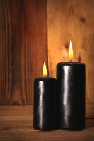 Black burning candles  wooden background. Symbols of witchcraft. Halloweenの写真素材
