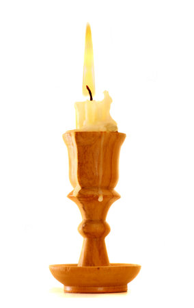 burning old candle vintage wooden candlestick. Isolated on white background.の写真素材