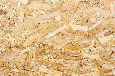 OSB boards are made of brown wood chips sanded into wooden background. Top view of OSB wood veneer background, tight, seamless surfaces.の写真素材