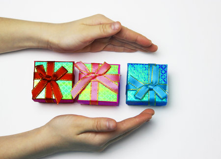 a gift in childrens hands, on a white background, a girl gives giftsの写真素材