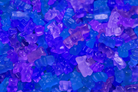 Colorful texture using as background. A lot of sweets. Background 3d rendering illustration. Orange and black multiple jelly candies in powdered sugar. Confectionery wallpaper concept. Copy space. Shallow focus. High quality photoの写真素材